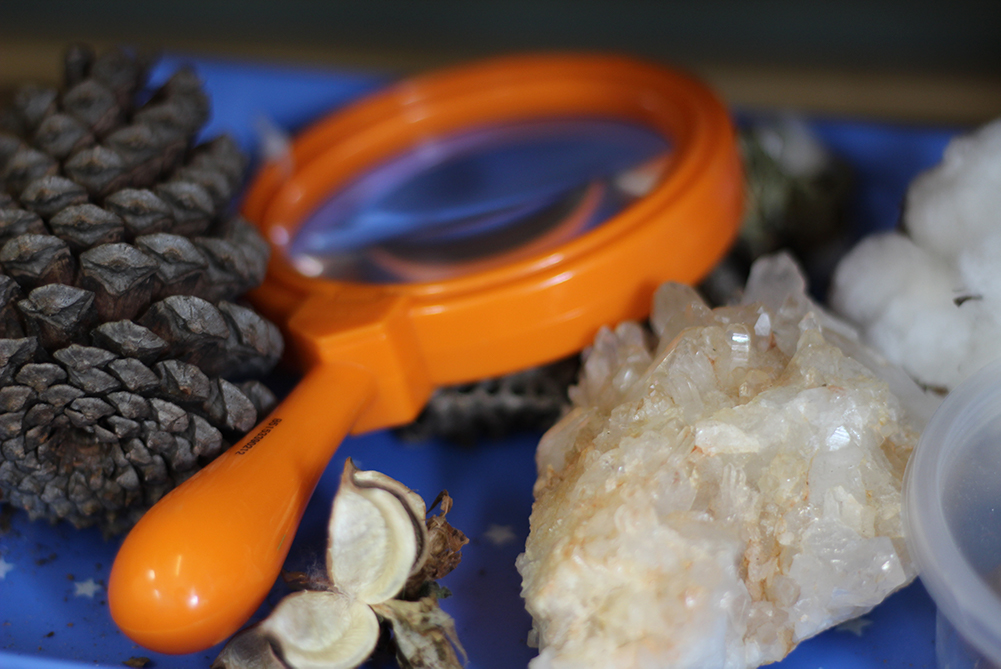 Magnifying glass with different types of rocks.